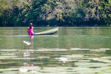 Rio Dulce, Guatemala - 10 Mart 2016: Rio Dulce Nehri, Guatemala kürek çekmeye yerel yerli kadın