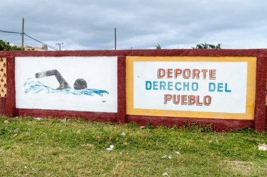 Gibara, Küba - 29 Ocak 2016: Duvar Gibara köy yüzme havuzunda bir duvar resmi. O says: spor, sağdaki halkların.