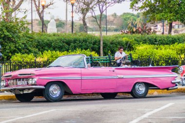Havana, Küba - 20 Şubat 2016: Parlak pembe eski model araba eski Havana'da turistler için bekler.