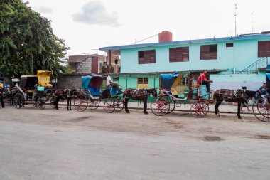 BAYAMO,  CUBA - JAN 30, 2016: Horse carriages are very common mean of transport in Bayamo, Cuba clipart