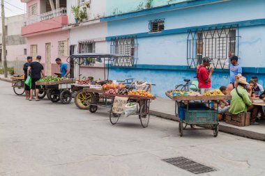 BAYAMO,  CUBA - JAN 30, 2016: Fruits and vegetables sellers with small carts. clipart