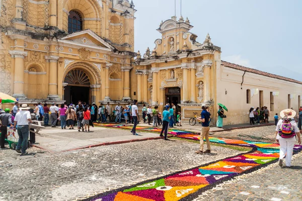 Antigua, Guatemala - 27 Mart 2016: Dekoratif boyunca insanlar yürüyüş Paskalya şehirde Antigua Guatemala, Guatemala San Pedro Apostol Kilisesi önünde halıları.