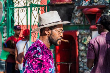 Havana, Küba - 21 Şubat 2016: yerel adam partiye Havana Centro mahalle sanatsal Callejon de Hamel sokakta bir puro sigara.