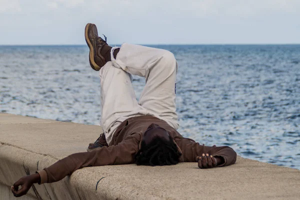 Havana, Küba - 21 Şubat 2016: Deniz sürücü Malecón için Havana'bir dış duvar, yerel adam rahatlatır.