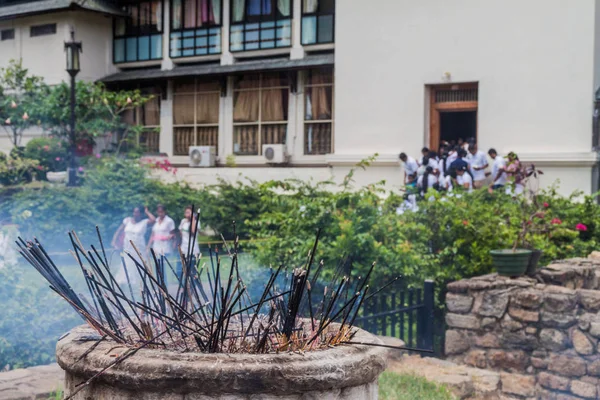 Incense sticks burn at the grounds of the Temple of Sacred Tooth Relic during Poya (Full Moon) holiday.
