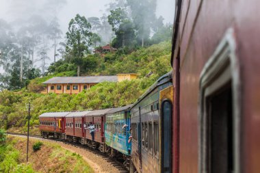 Idalgashinna, Sri Lanka - 16 Temmuz 2016: Yerel tren Idalgashinna köyü yakınlarında sürmek. Yerli kapı dışarı asmak.
