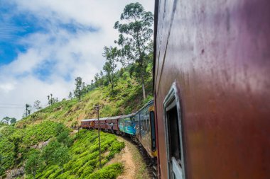Idalgashinna, Sri Lanka - 16 Temmuz 2016: Yerel tren Idalgashinna köyü yakınlarında sürmek. Yerli kapı dışarı asmak.