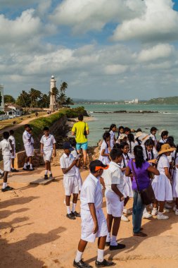 Galle, Sri Lanka - 12 Temmuz 2016: Okul üniformalı Galle sur duvarları bir denizden kulak.