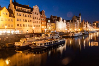 Gdansk, Polonya - 1 Eylül 2016: Motlawa Nehri, Gdansk, Polonya tarafından nehir kıyısındaki evlerin akşam görünümü. Arka planda Ortaçağ vinç.