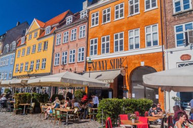Copenhagen, Danimarka - 26 Ağustos 2016: İnsanlar oturup restoran ve kafelerde bölgesi Nyhavn Kopenhag, Danimarka