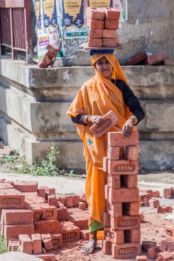 Delhi, Hindistan - 22 Ekim 2016: Delhi, Hindistan merkezinde başında bir sürü tuğla taşıyan kadın işçi.