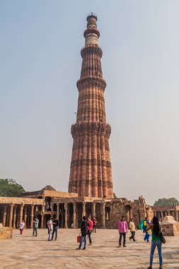 Delhi, Hindistan - 23 Ekim 2016: Turist Qutub Delhi, Hindistan karmaşık ziyaret edin. Qutub Minar minaresi görünür.