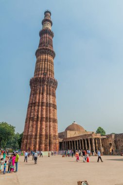 Delhi, Hindistan - 23 Ekim 2016: Turist Qutub Delhi, Hindistan karmaşık ziyaret edin. Qutub Minar minaresi görünür.