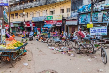 Varanasi, Hindistan - 25 Ekim 2016: Street meyve tezgahları ve cyclo rickshaws Varanasi, Hindistan