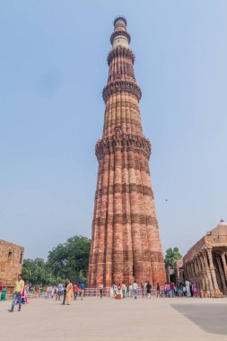 Delhi, Hindistan - 23 Ekim 2016: Turist Qutub Delhi, Hindistan karmaşık ziyaret edin. Qutub Minar minaresi görünür.