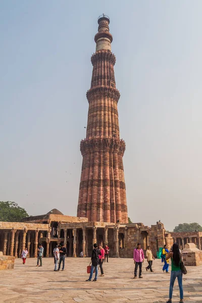 Delhi, Hindistan - 23 Ekim 2016: Turist Qutub Delhi, Hindistan karmaşık ziyaret edin. Qutub Minar minaresi görünür.