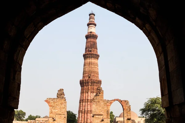Bir kapıdan Qutub Minar minaresi görünümünü. Delhi, Hindistan.