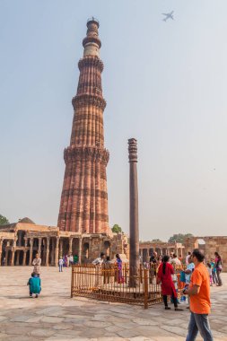 Delhi, Hindistan - 23 Ekim 2016: Turist Qutub Delhi, Hindistan karmaşık ziyaret edin. Qutub Minar minaresi ve demir sütun görünür.