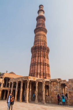 Delhi, Hindistan - 23 Ekim 2016: Turist Qutub Delhi, Hindistan karmaşık ziyaret edin. Qutub Minar minaresi görünür.