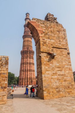 Delhi, Hindistan - 23 Ekim 2016: Turist Qutub Delhi, Hindistan karmaşık ziyaret edin. Qutub Minar minaresi görünür.