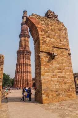 Delhi, Hindistan - 23 Ekim 2016: Turist Qutub Delhi, Hindistan karmaşık ziyaret edin. Qutub Minar minaresi görünür.