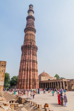 Delhi, Hindistan - 23 Ekim 2016: Turist Qutub Delhi, Hindistan karmaşık ziyaret edin. Qutub Minar minaresi görünür.