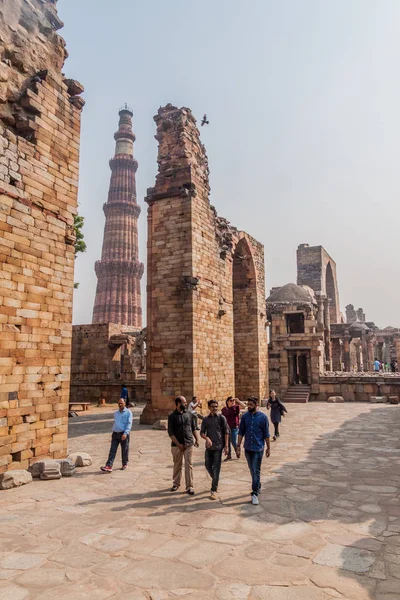 Delhi, Hindistan - 23 Ekim 2016: Turist Qutub Delhi, Hindistan karmaşık ziyaret edin. Qutub Minar minaresi görünür.