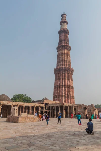 Delhi, Hindistan - 23 Ekim 2016: Turist Qutub Delhi, Hindistan karmaşık ziyaret edin. Qutub Minar minaresi görünür.