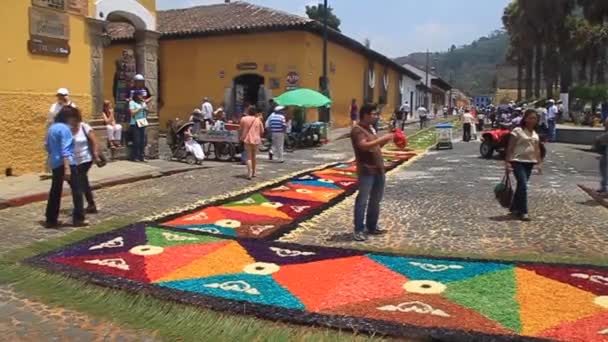Люди ходят по декоративным пасхальным коврам — стоковое видео