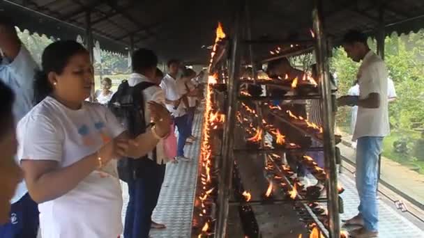 Los devotos budistas vestidos de blanco encienden velas — Vídeos de Stock