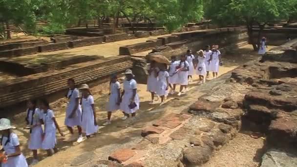 Crianças de uniforme escolar visitam cidade antiga Polonnaruwa — Vídeo de Stock