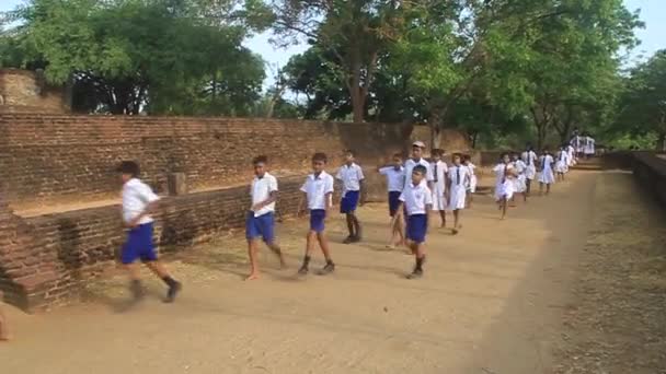Dzieci w mundurki odwiedź starożytne miasto Polonnaruwa — Wideo stockowe