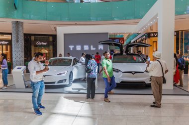 DUBAI, UAE - MARCH 12, 2017: Two Tesla cars exhibited in the Dubai Mall, one of the largest malls in the world. clipart