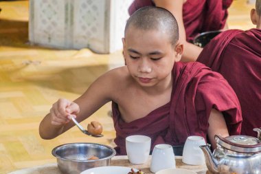 Bago, Myanmar - 10 Aralık 2016: Bago tapınağında rahipler Kya Kha Wain Kyaung onların öğle yemeği yemek.