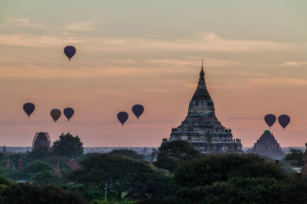 Balloons over Bagan and the skyline of its temples, Myanmar. Sulamani temple and Shwesandaw pagoda.