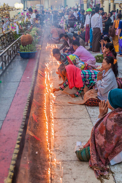 МТ КЯИКТИЙО, МЯНМАР - 11 ДЕКАБРЯ 2016 г.: Пилигримы молятся на горе Кяйктиё (Золотая Скала), Мьянма
