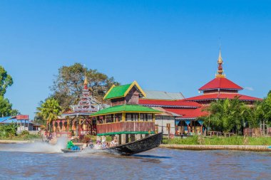 Inle, Myanmar - 26 Kasım 2016: Turistlerin olduğu tekne, Myanmar'ın Inle gölünde bir manastırın yanından geçiyor