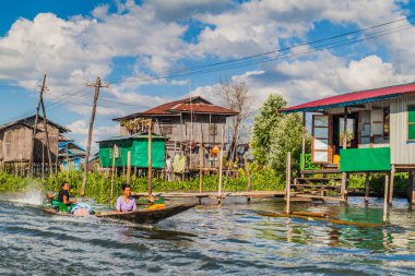 Inle, Myanmar - 28 Kasım 2016: Inle gölündeki ayaklı evler arasında teknede halk, Myanmar