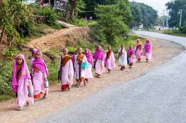 Hsipaw, Myanmar - 1 Aralık 2016: Genç Budist rahibeler Myanmar'ın Hsipaw kenti yakınlarındaki bir köyde sabah sadakaları için gidiyor