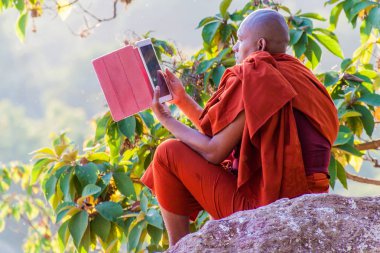Mandalay, Myanmar - 3 Aralık 2016: Mandalay tepesinde tablet bilgisayarıyla Budist keşiş, Myanmar