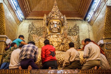 Mandalay, Myanmar - 4 Aralık 2016: Mandalay, Myanmar'daki Mahamuni Buddha Tapınağı'nda Budist adanmışlar Buddha'ya altın yapraklar koydular