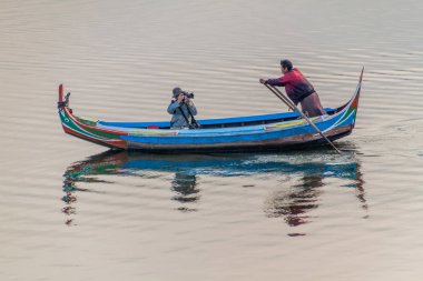 Mandalay, Myanmar - 4 Aralık 2016: Mandalay yakınlarındaki Amarapura'daki Taungthaman gölünde bir fotoğrafçıyla tekne, Myanmar