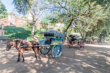Inwa, Myanmar - 5 Aralık 2016: Myanmar'ın Mandalay kenti yakınlarındaki Inwa (Ava) antik kentinde turistleri bekleyen at arabaları