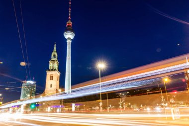 Berlin, Almanya - 9 Ağustos 2017: Marienkirche (St. Mary Kilisesi) ve Fernsehturm'un (Tv kulesi) trafik bulanıklığıyla akşam manzarası.