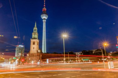 Berlin, Almanya - 9 Ağustos 2017: Marienkirche (St. Mary Kilisesi) ve Fernsehturm'un (Tv kulesi) trafik bulanıklığıyla akşam manzarası.