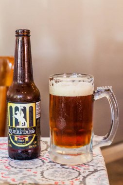 Queretaro, Meksika: 3 Ekim 2016: Queretaro, Meksika'da bir restoranda bir bardak ile Queretaro bira şişesi