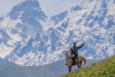 Alamedin, Kırgızistan - 21 Mayıs 2017: Alamedin vadisindeki bir çayırda at üzerinde herdsman.