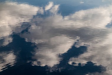 bulutlar bir suya yansıtan