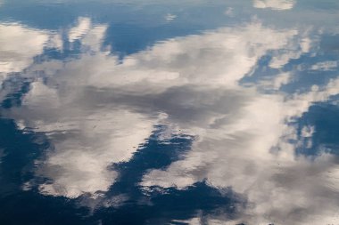 bulutlar bir suya yansıtan