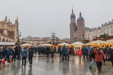 Krakow, Polonya - 4 Aralık 2017: Krakow, Polonya'daki St. Mary Bazilikası ile rynek Glowny adlı ortaçağ meydanında Noel pazarı tezgahları